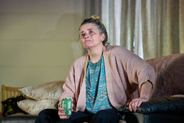 Theatre Lighting Programmer London a woman sits on a couch holding a can of heineken beer