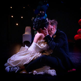 Theatre Lighting Programmer London a bride and groom kissing on a stage with balloons in the background