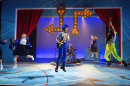 Theatre Lighting Programmer London a man in a blue mohawk is playing a guitar on a stage