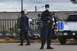 Police Stand Guard As Officers Test Body Of Dead Man For Ebola Virus In Monrovia