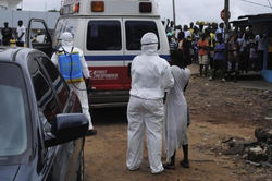 Health Workers Bring Woman Suspected Of Having Contracted Ebola Virus To Ambulan