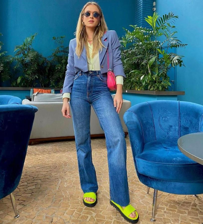 mulher com blazer cropped e calça jeans