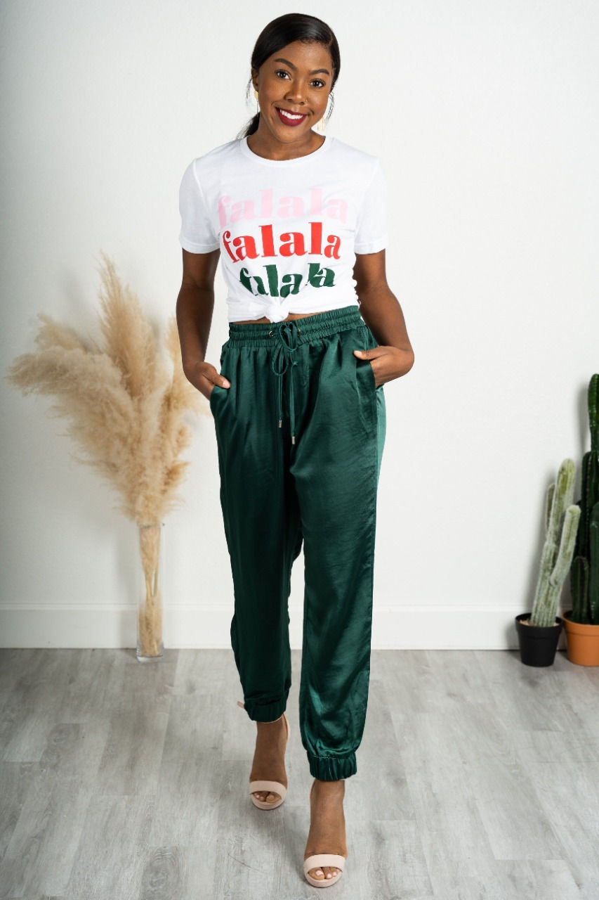 mulher com look de final de ano, camisa branca e calça verde