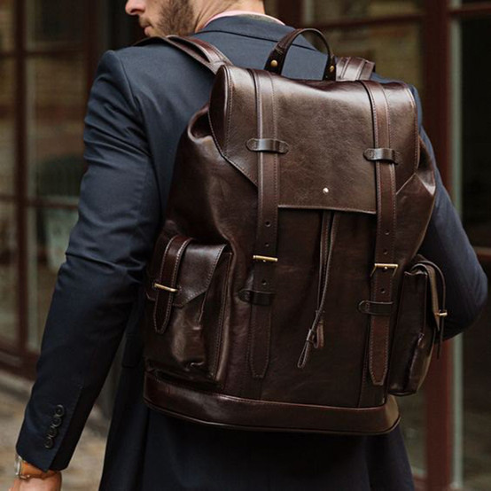 homem de costas usando mochila de couro