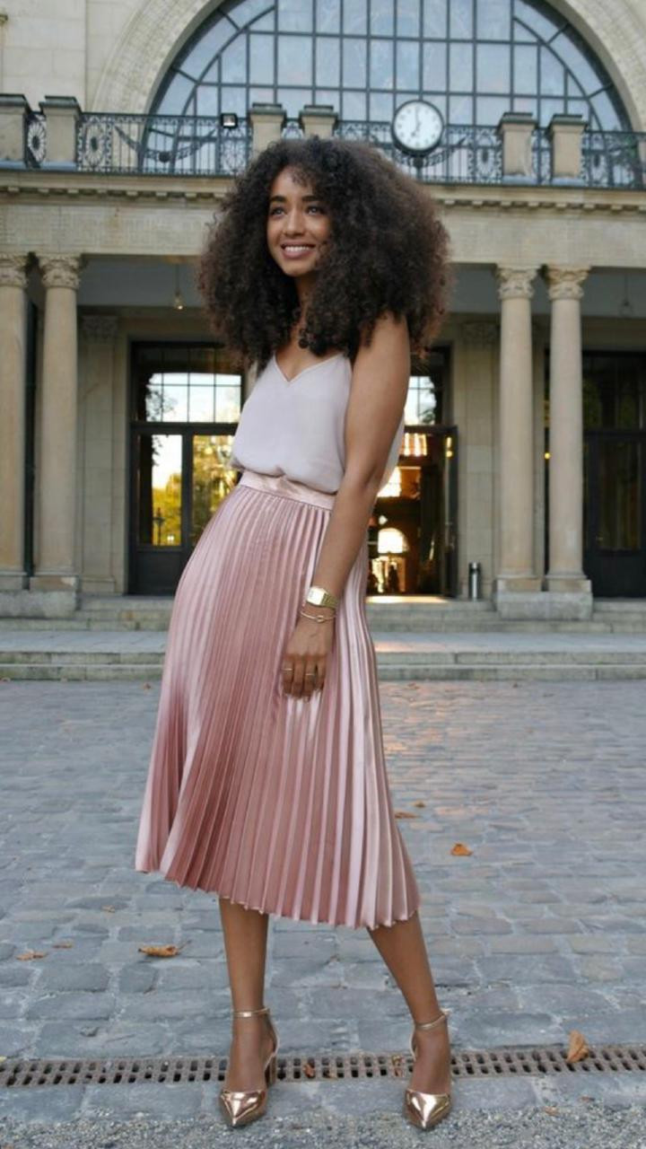 mulher cabelo cacheado com saia midi rosa