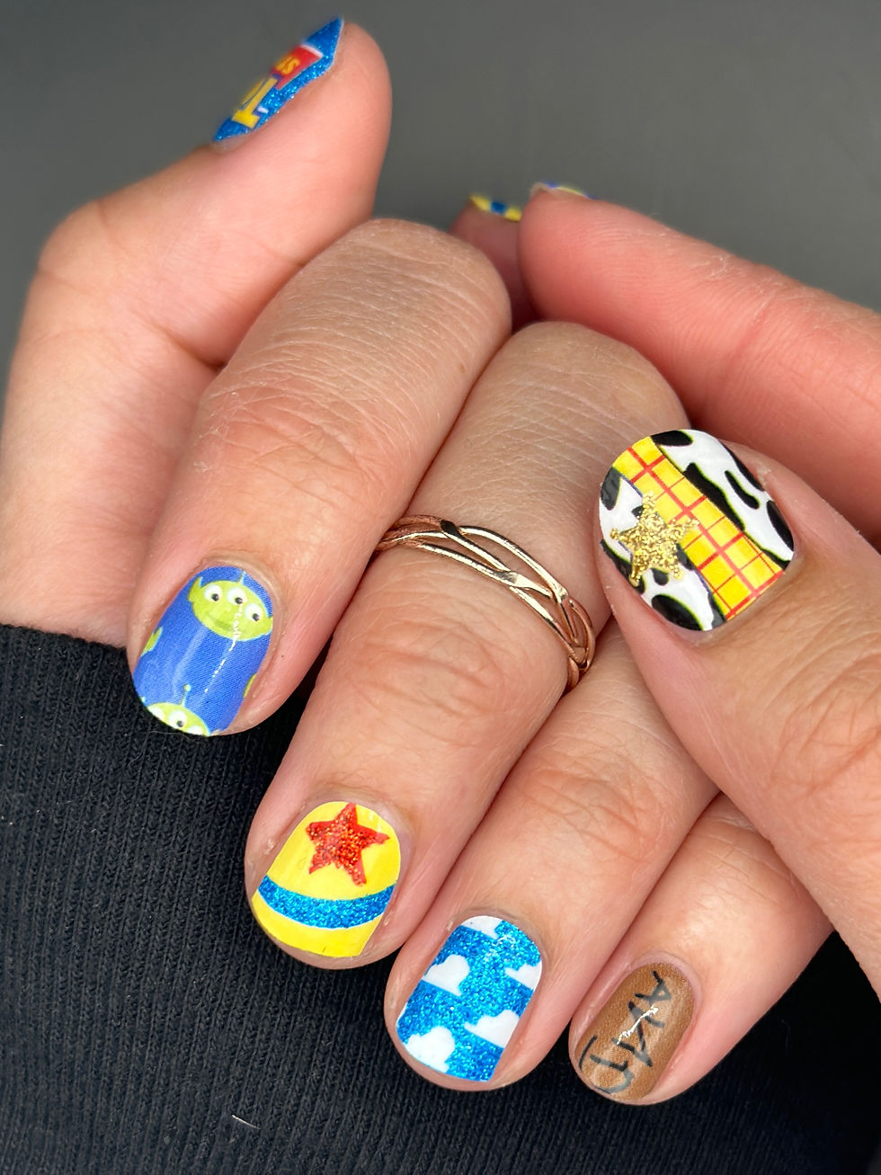 Al’s Toy Barn themed nail art featuring playful Pixar-style prints