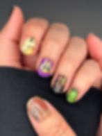 Hand wearing Hocus Pocus Disney Halloween nails with Sanderson Sisters, spell book, dripping candle wax, green glitter, and w