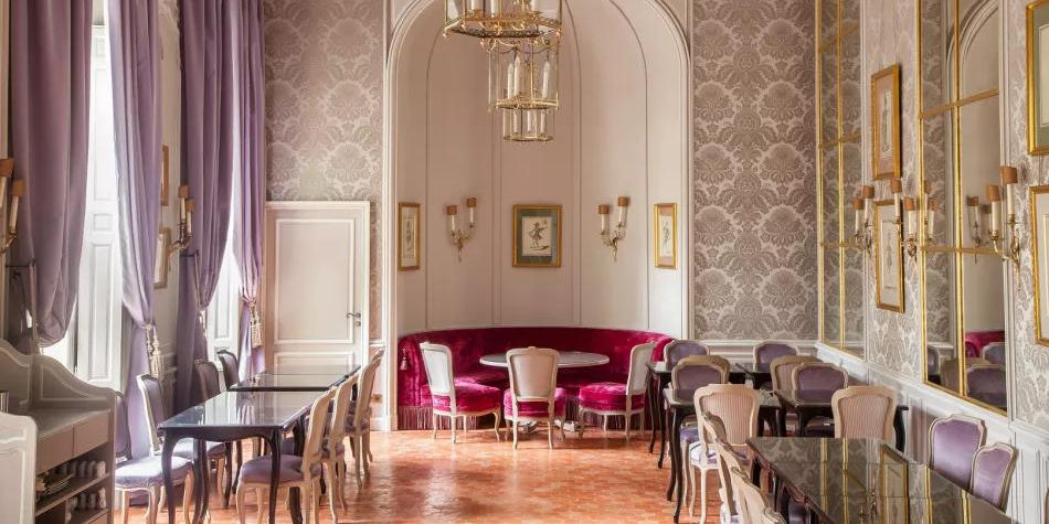 Salle élégante du café-restaurant de l’Hôtel de Caumont avec tables et décoration classique à Aix-en-Provence