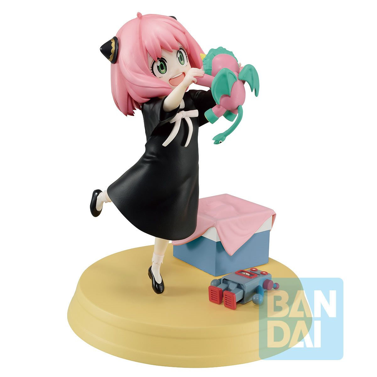 Anya Forger anime figure holding a toy, BANDAI logo on base, smiling happily.