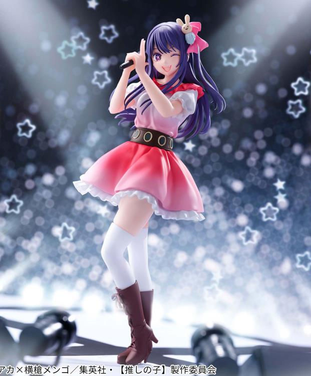 Thumbnail: Anime girl figure with microphone on stage, smiling and posing. Star background.