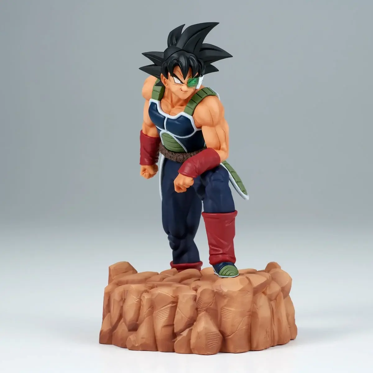 Action figure of Bardock from Dragon Ball Z series stands on rock formation.
