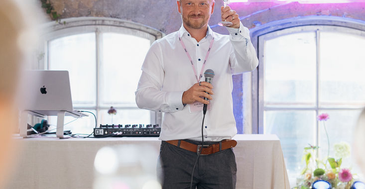 Antti Ikonen pitämässä puhetta pinkin Folks valokyltin alla