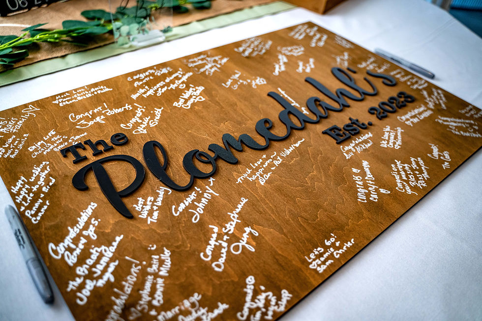 Wedding guestbook board with white handwritten notes and signatures, warm toned wood. unique guest book alternative