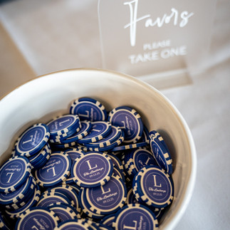 Golf ball markers with an L in white on a blue background make a creative wedding favor