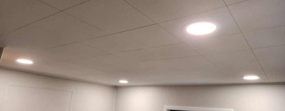 Recessed ceiling lights in a white drop ceiling above freshly painted gray walls