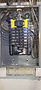 New Square D Homeline panel with the cover off, 100 amp main breaker with yellow guards and neat rows of new breakers