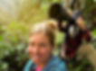 male with a long telephoto lens shooting rare birds in a colombian rainforest while the female companion takes a selfie of the moment