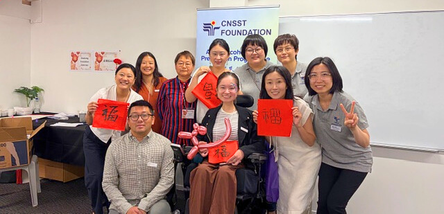 Community members holding calligraphy artwork at Lantern Festival Community Health Day