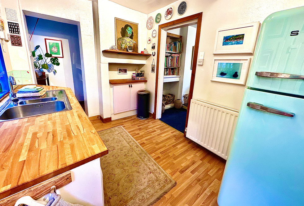 Pink and green kitchen with wooden worktops