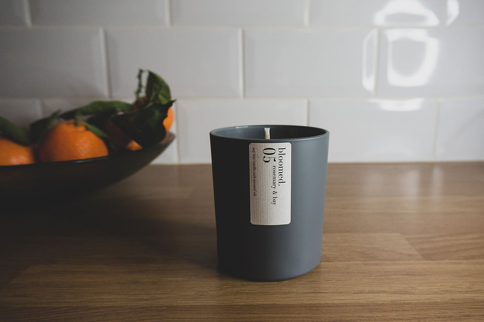 candle in the kitchen by a bowl of oranges