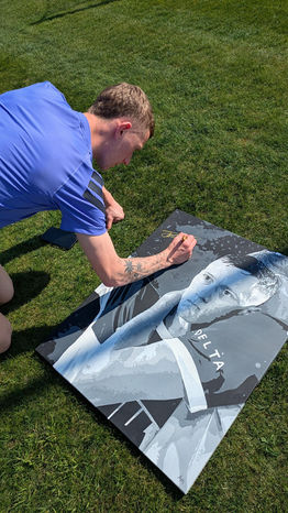 Birmingham City's Jay Stansfield signing a bespoke piece sold at auction for the Adam Stansfield Foundation