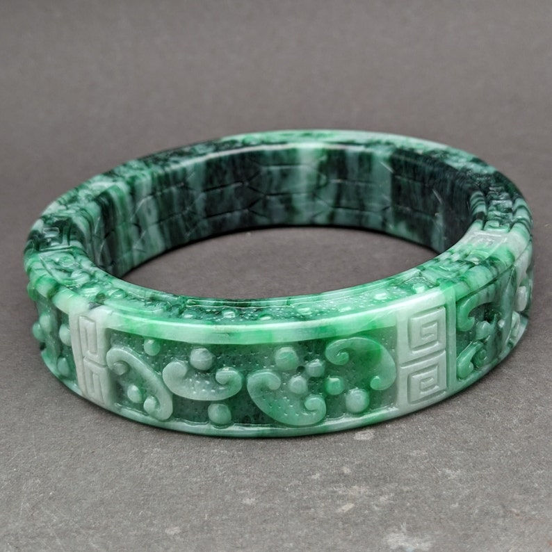 Natural jade bangle: Jadeite bangle carved with dragon and phoenix, symbol of
