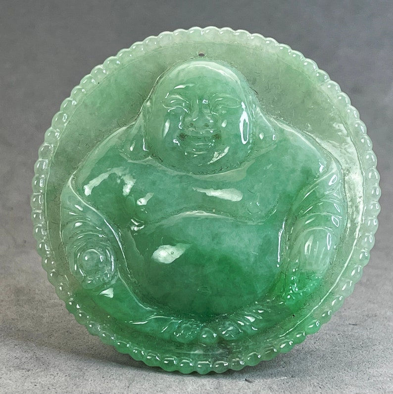 Hand carved green and translucent jade pendant of a seated happy buddha