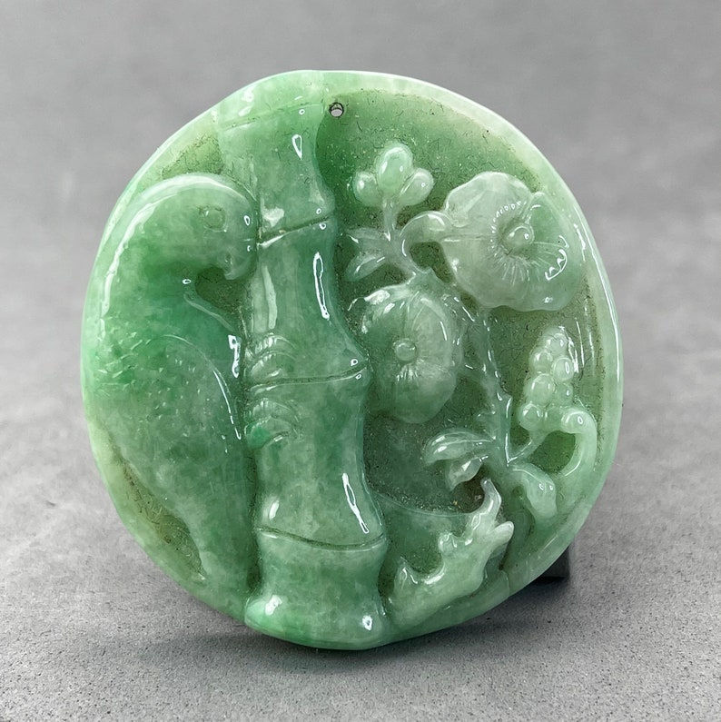 Hand carved and polished green Jadeite parrot pendant, bamboo and flower