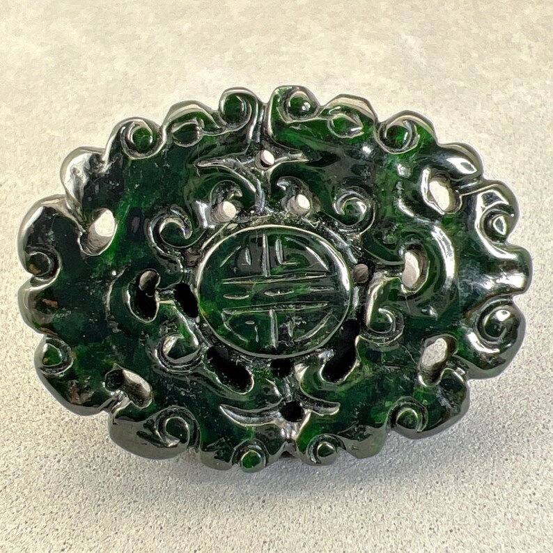 Jadeite carving: dark spinach jade charm, carved with longevity symbol