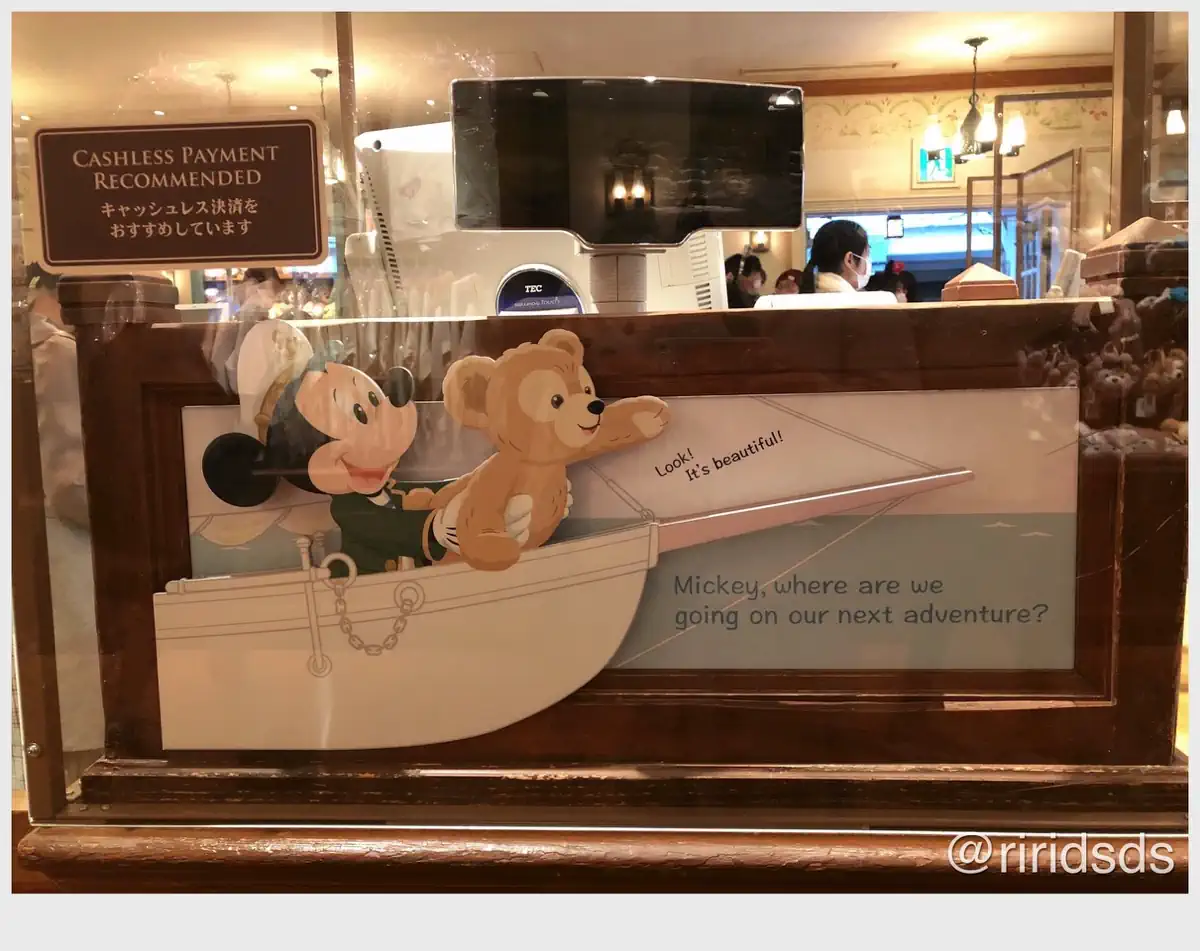 Duffy and Mickey are in their boat. Mickey is holding onto Duffy as Duffy leans over the ledge and points his paw forward