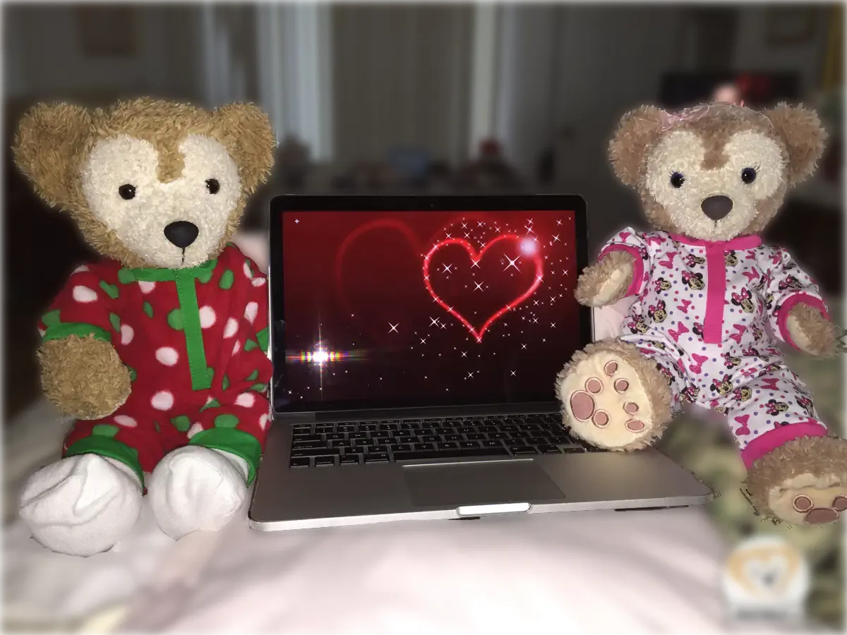 Duffy and ShellieMay sit on either side of Duffy's laptop. There is a screen picture with red hearts for Valentine's Day