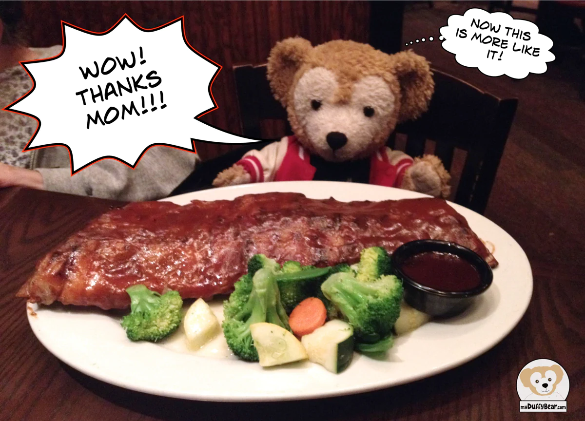 Duffy has a huge rack of ribs with a few veggies on the plate in front of him. He's so happy!