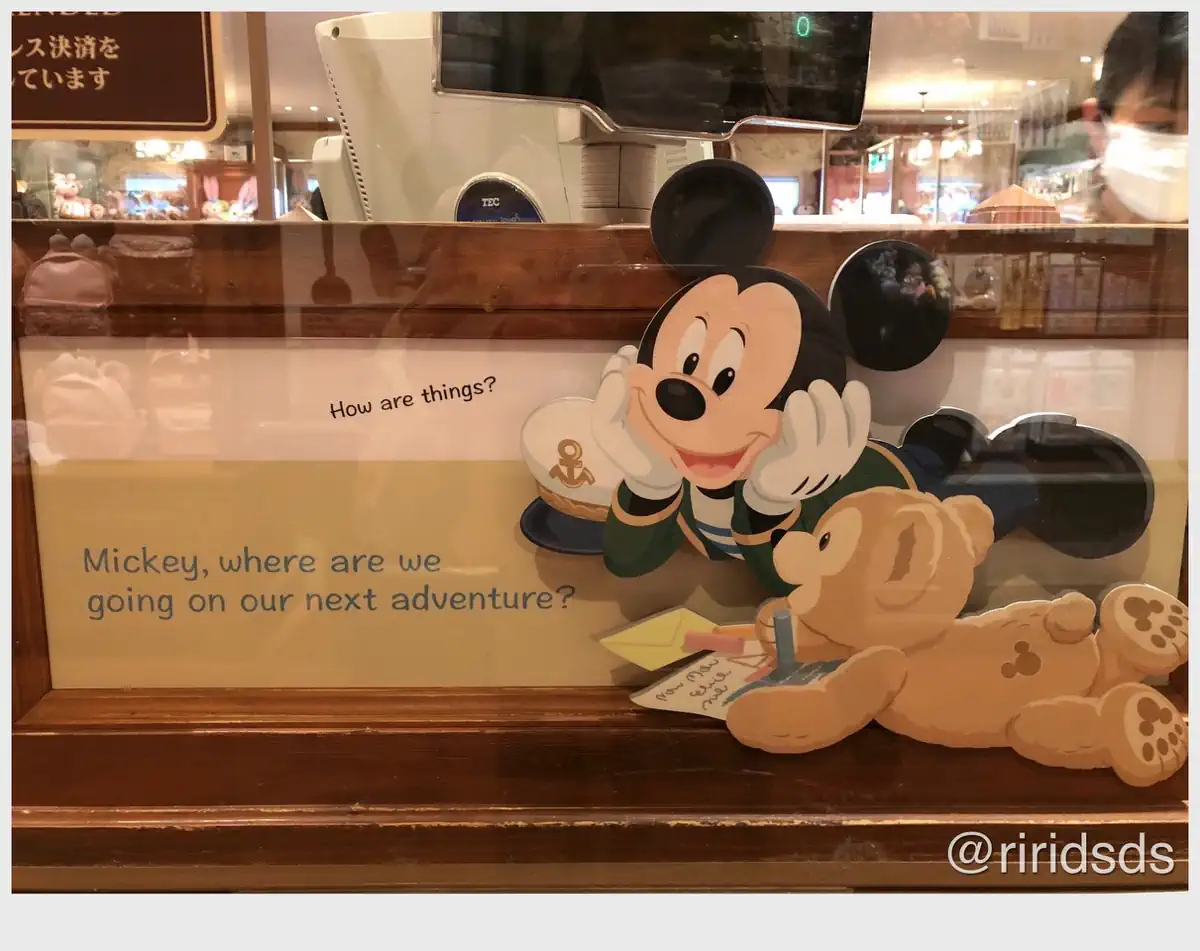 Duffy the Disney Bear writing a letter with Mickey Mouse by his side