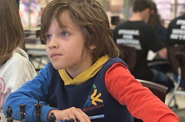 A child challenging another player to a game of chess.