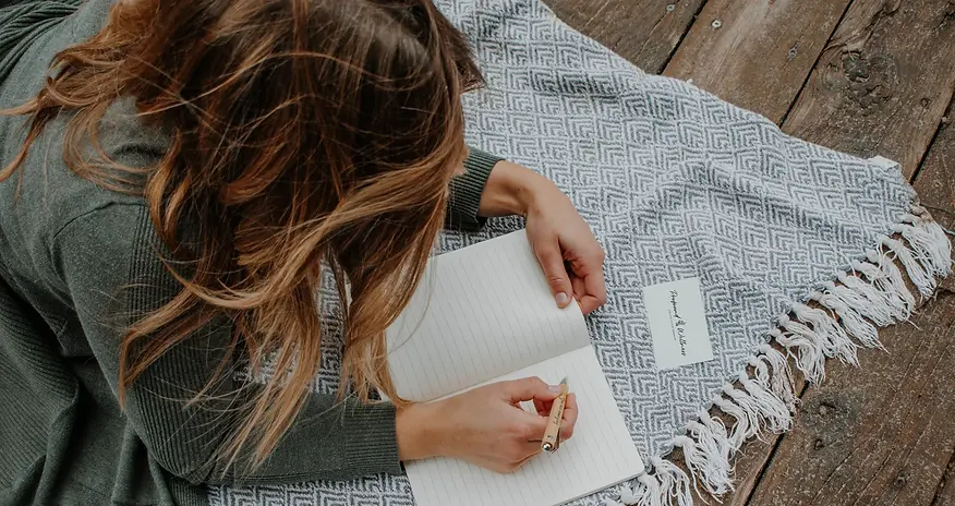 Meg Laidlaw, Holistic Health Coach and Board Certified Nurse Coach, journaling in nature.