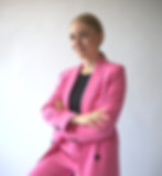 Amanda Burch in pinkem Blazer schaut mit verschränkten Armen in Kamera