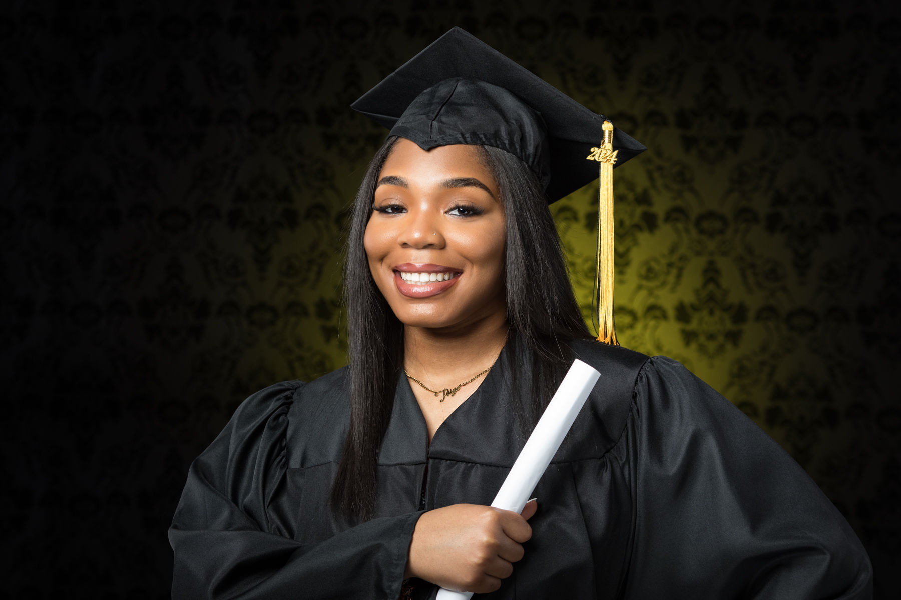 Black female in graduate cap and gown senior portrait