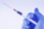 Syringe in gloved hand