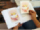 Hands flipping through a personalized keepsake card book with a greeting card and caption preview
