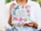 Close-up of a person holding a custom Artkive card book with floral cover design and personalized title