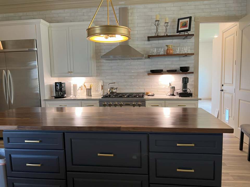 Functional kitchen remodel in Houston, TX, featuring custom dark cabinetry, large quartz island, and modern stainless steel appliances. Turnkey kitchen renovation project by Bager.
