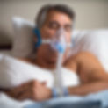 man wearing a cpap machine in bed.jpg