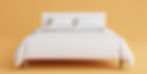 White bed with two pillows against an orange background, creating a calm and minimalist atmosphere.