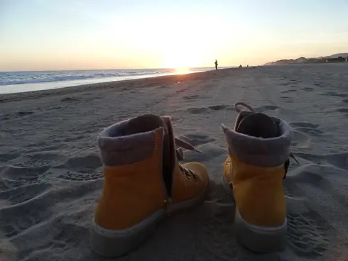 Gelbe Stifeltten auf einem Sandstrand bei Abenddämmerung