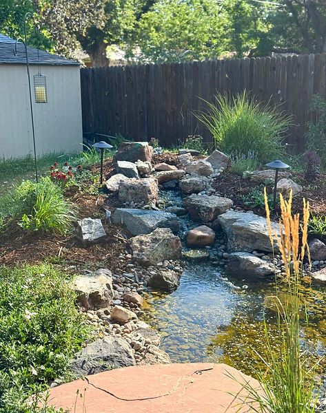 Natural stone water feature and stream in backyard landscaping, Arvada, CO