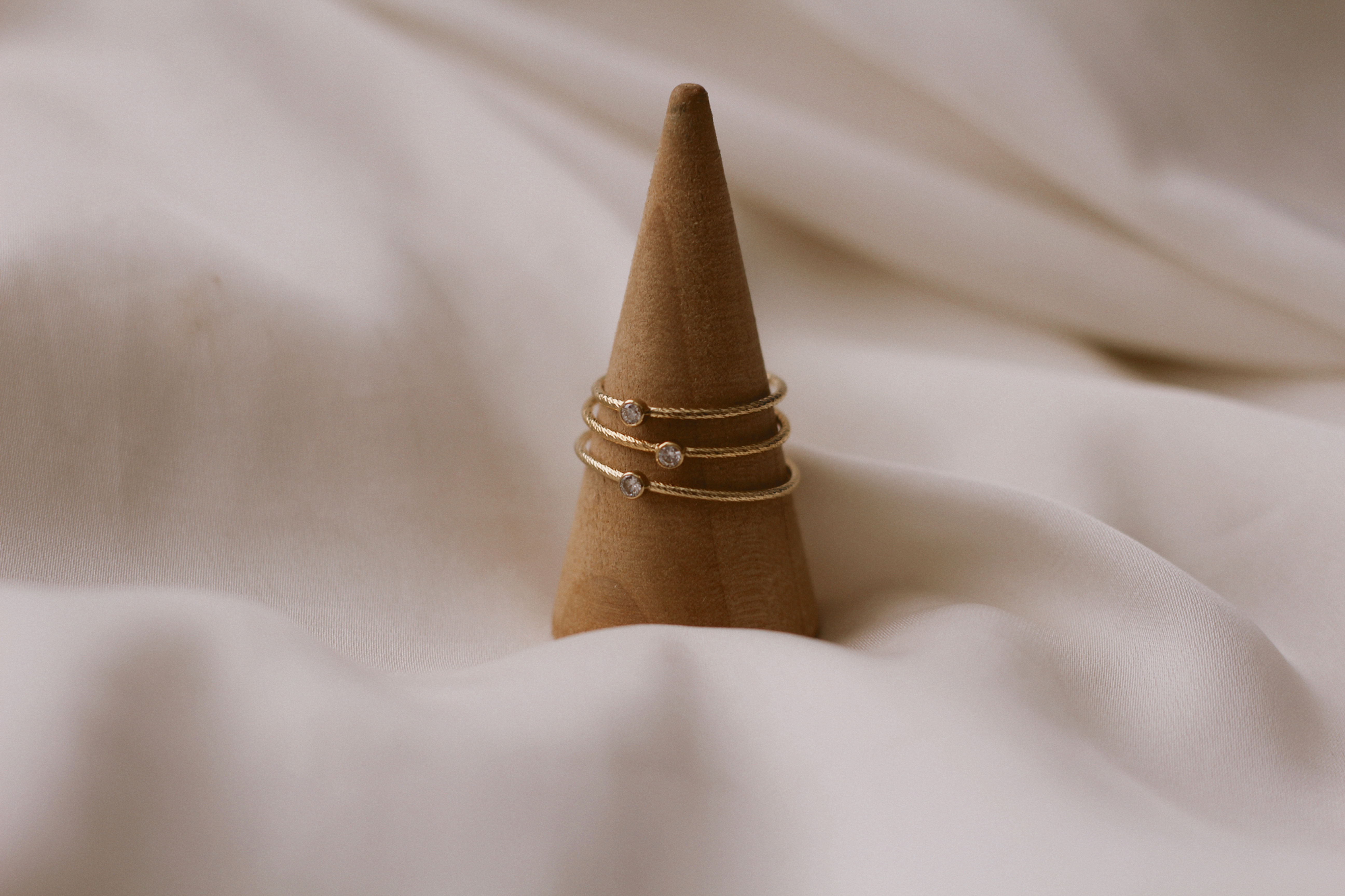 Three dainty gold stacking rings with a tiny CZ sparkle on each