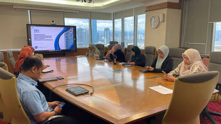 Professionals attending a meeting with a presentation on screen