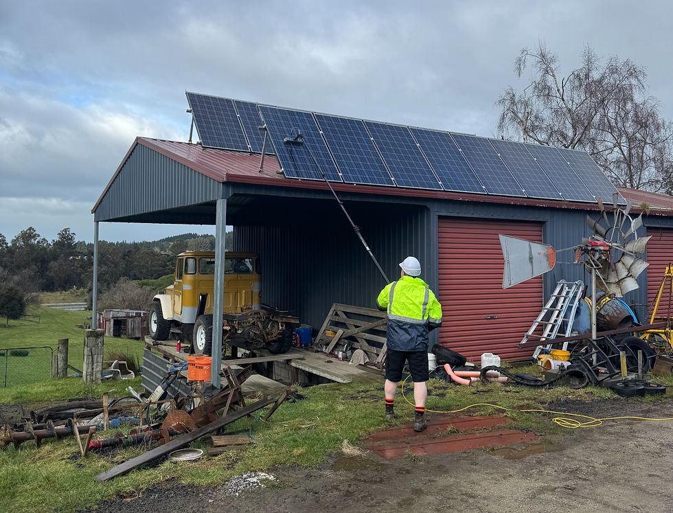 Eco Solar Clean cleaning large shed-mounted solar array in Fairfield, Dunedin, removing lichen and grime for improved efficiency.