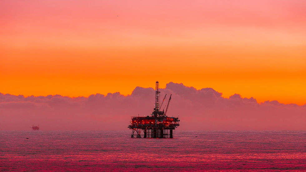 Oil rig in the ocean at sunset