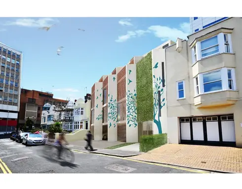 Modern building with tree and bird murals and vertical greenery along a street